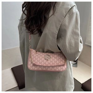 Pink printed shoulder bag with metal M logo and stylish chain strap detail shown on model