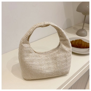 Détail du sac hobo minimaliste en paille avec fermeture éclair et texture tressée