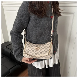 Detail of beige monogram shoulder bag with gold hardware and metal chain strap