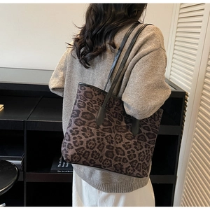 Detailed view of large leopard print tote bag with black leather shoulder straps