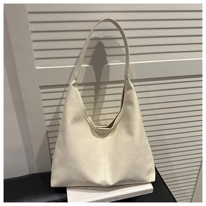 Detail of a creamy white textured leather hobo bag with unique vertical stitching details