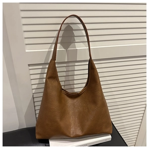 Detail of vintage brown tote bag showing smooth leather texture and vertical stitching