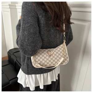 Details der beigen Monogramm-Tasche mit goldenem M-Logo und eleganten doppelten Riemen