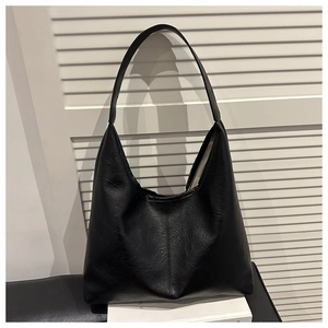 Detail of black large capacity hobo bag with textured faux leather and vertical stitching