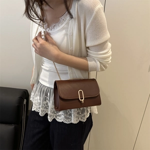 Sac bandoulière marron foncé minimaliste avec chaîne dorée et fermoir rotatif ovale