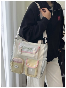 Détails de sac cabas en toile à poches multiples avec coutures contrastées et texte