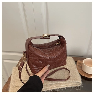 Detailed view of brown quilted heart pattern crossbody bag with gold hardware and zipper