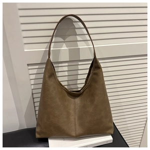 Detail view of large brown hobo tote bag with vintage leather texture and vertical stitching