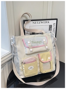 Détail du sac seau en nylon de style collège avec poches contrastées et broderie logo