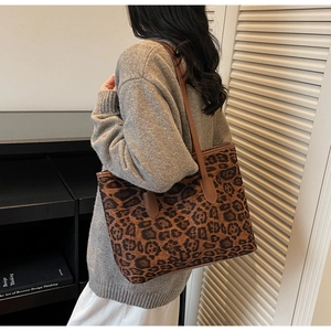 Close-up of leopard print tote bag featuring brown leather straps and vintage design