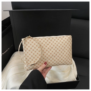 Detail of elegant patterned clutch with gold ring handle in a premium gift box setup