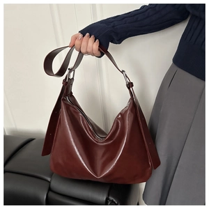 Détail du sac cabas en cuir verni bordeaux avec fermeture éclair et bandoulière