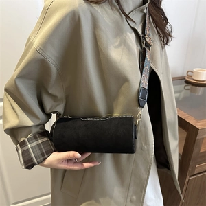 Minimalist black cylinder pillow bag with decorative jacquard wide shoulder strap for women