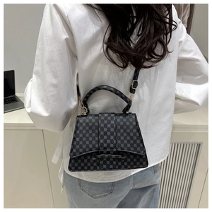 Achteraanzicht van een getextureerde crossbodytas met geometrische patronen op model