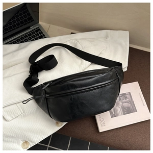 Détail de la texture en similicuir noir vintage et bandoulière réglable du sac de poitrine