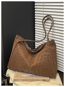 Détail du sac cabas léopard montrant la texture en daim et la fine bandoulière réglable