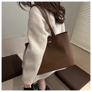 Vue détaillée du grand sac cabas en cuir marron foncé avec poche et logo gaufré
