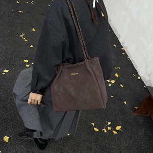 Brown large capacity tote bag with woven shoulder straps and gold lettering detail