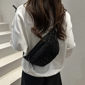 Black leopard print canvas crossbody bag with adjustable strap and crescent shape