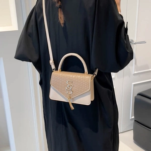 Sac bandoulière minimaliste beige et marron avec texture serpent et pompon décoratif