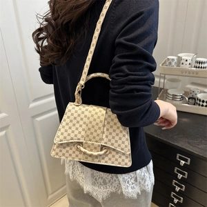Chique beige handtas in zandlopervorm met monogrampatroon en modieuze schouderriem