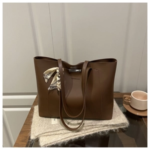 Détail du sac cabas en similicuir marron avec poche avant et foulard en soie décoratif