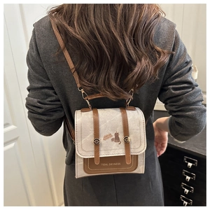 Detail of a vintage mini backpack with cat illustration and brown leather straps