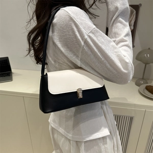 Borsa sottobraccio minimalista bianca e nera con chiusura in metallo in set lifestyle