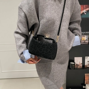 Retro black leopard print crossbody bag with gold buckle and slim strap on model