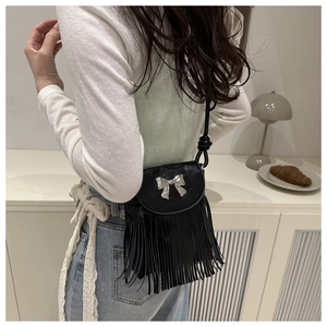 Detailansicht einer schwarzen Ledertasche mit silberner Schleife und langen Fransen