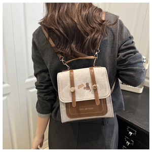 Detail of the vintage mini backpack showing cream canvas and brown leather patchwork design