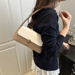 Elegante borsa baguette in pelle beige e crema con fibbia in metallo dorato sulla spalla