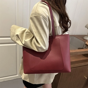 Sac fourre-tout bordeaux minimaliste avec poche avant porté à l'épaule