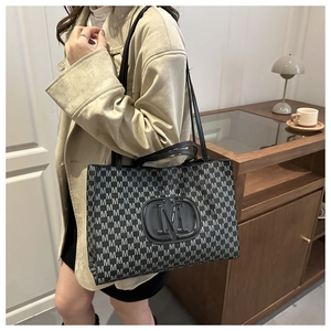 Close-up of stylish large tote bag with M-pattern print in a cozy home setting