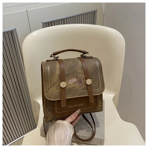Detail of vintage brown leather backpack with retro metal buckles and cat illustration
