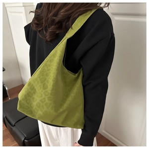 Green leopard print tote bag worn on shoulder showing large capacity and soft texture