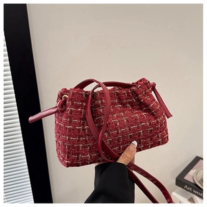 Detailansicht der burgunderroten Tweed-Beuteltasche mit verwebten Goldfäden-Texturen