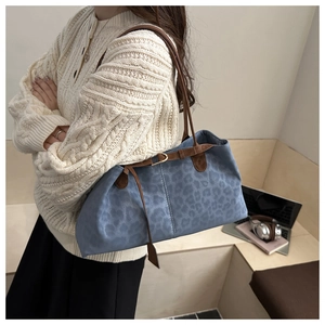 Detailansicht der blauen Leoparden-Tasche mit braunem Gurt und Metallschnalle
