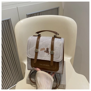 Detail of vintage grey fabric backpack with cat illustration and brown leather straps