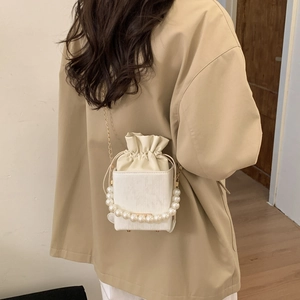 Chic white box bag with large pearl handle and metal chain strap shown on model