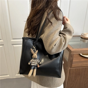Large black faux leather tote bag for women featuring a stylish rabbit doll pendant