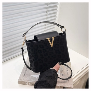 Détail du sac bandoulière noir à motif léopard avec boucle en V dorée et texture