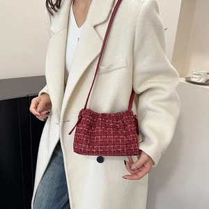 Rote Tweed-Beuteltasche mit Kordelzug, Goldfäden und Lederriemen auf weißem Mantel