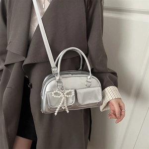 Silver metallic textured crossbody bag with pearl bow charm and dual front pockets