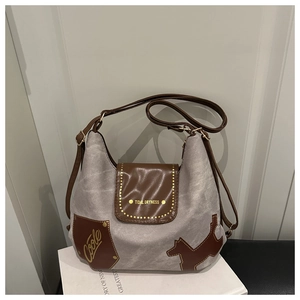 Detailaufnahme der Canvas-Tasche mit braunem Lederdeckel, Golddruck und Hundepatches