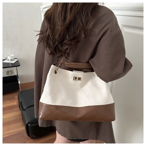Detailed view of tote bag with contrast cream and brown quilted leather and chain strap