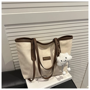 Canvas tote bag with dark brown leather trim, tidal logo, and plush cloud keychain charm