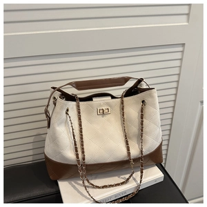 Detail of quilted canvas tote with gold-tone twist lock and leather-chain strap