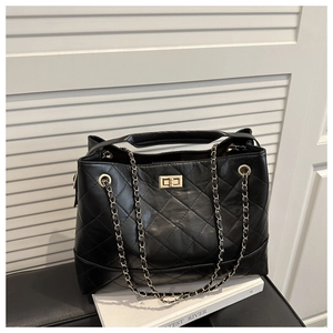 Detail of quilted leather pattern with golden twist lock and metal chain strap