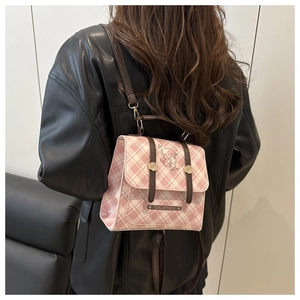 Detailed view of the pink and white plaid fabric backpack with cute bear illustration